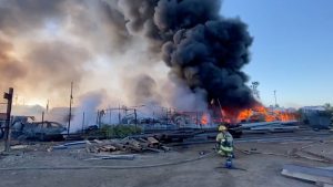 Phoenix auto yard fire pours dark smoke into morning sky