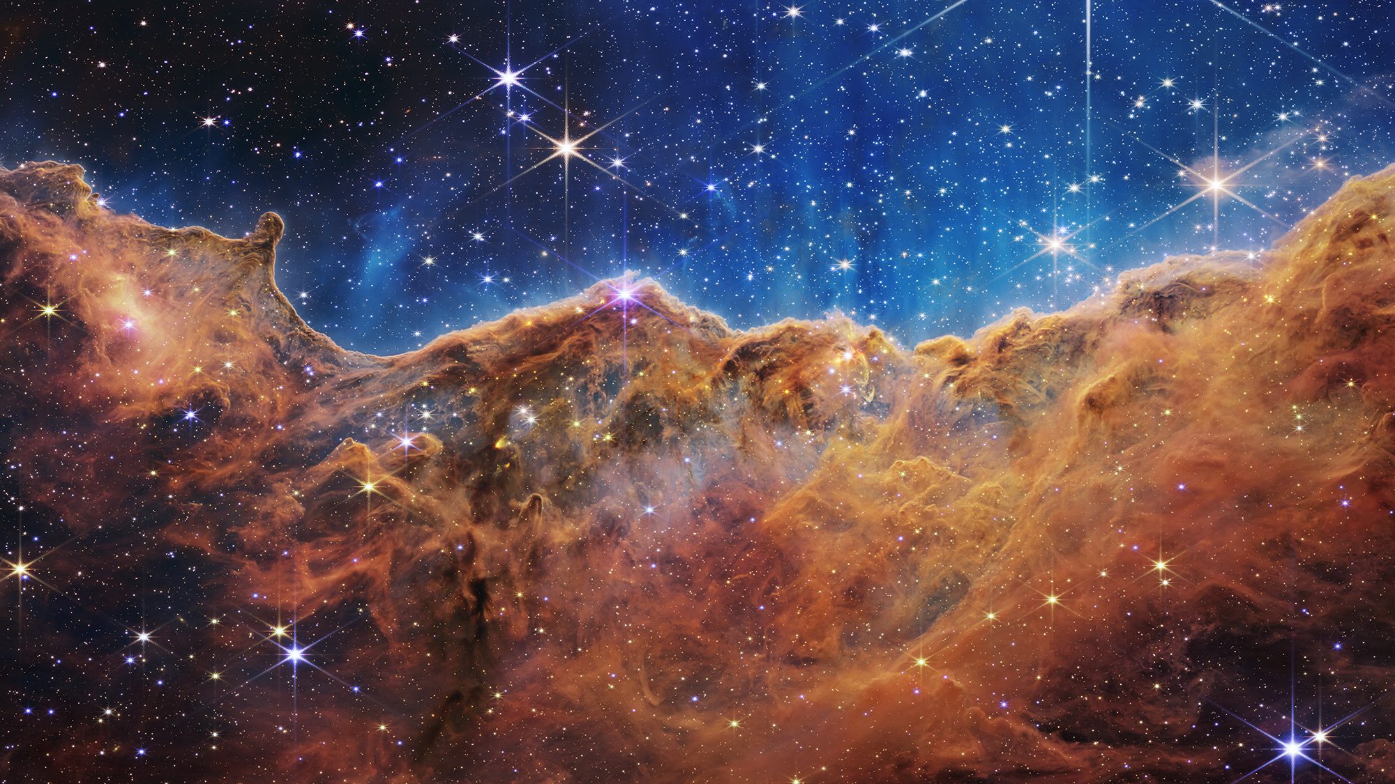 What looks like craggy mountains on a moonlit evening is actually the edge of a nearby, young, star...