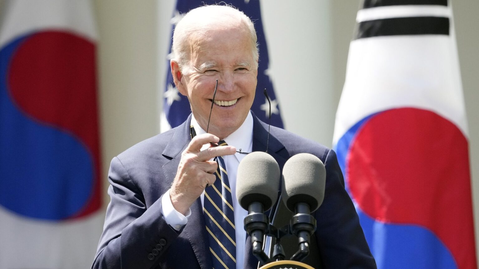 President Joe Biden takes his sunglasses off at a news conference with South Korea's President Yoon...
