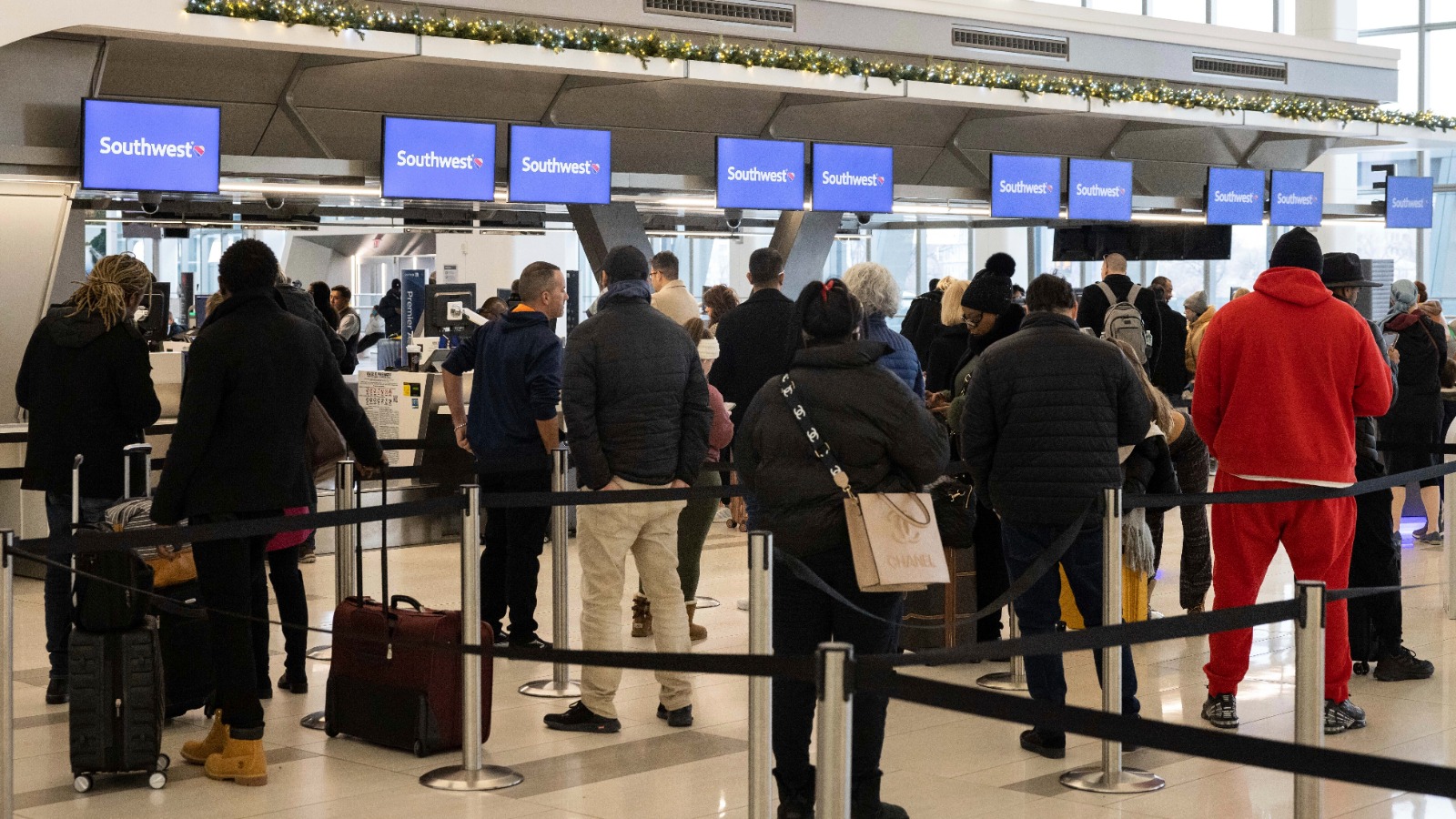 FILE - Passengers wait in line to check in for their flights at Southwest Airlines service desk at ...