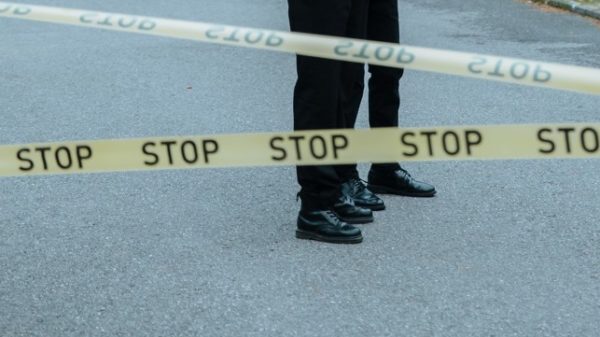 feet pictured in front of caution tape...