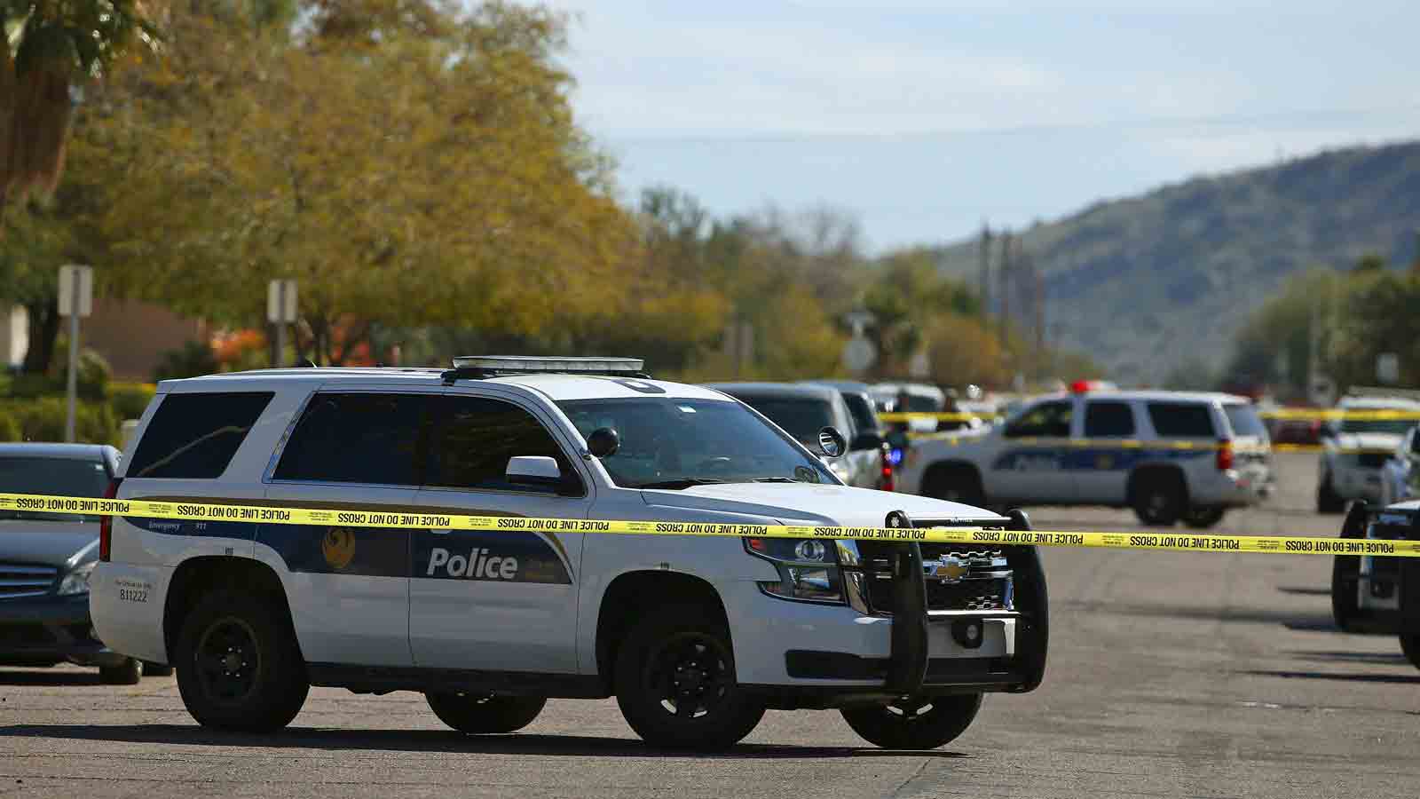 Police cars parked in what appears to be a residential neighborhood...
