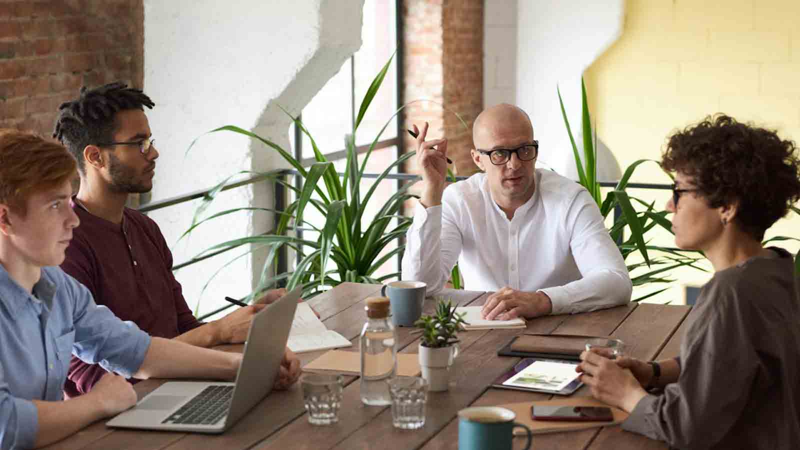 People gather at table for what appears to be a business meeting....