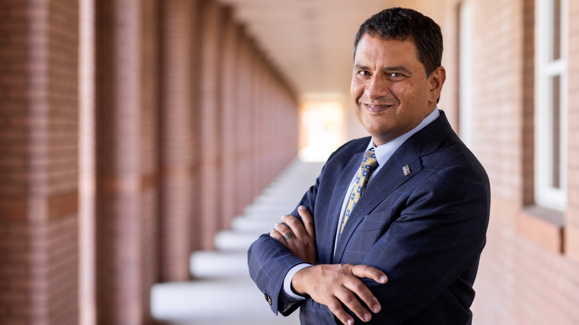 NAU President Jose Luis Cruz Rivera folds his arms and smiles for a photo....
