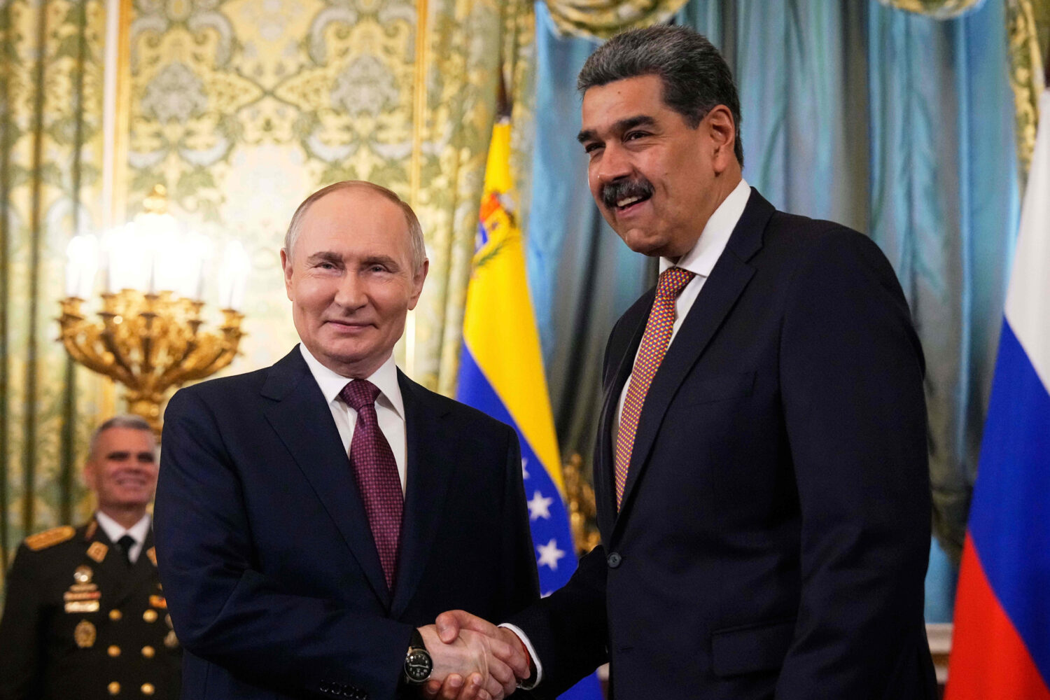 FILE - Russian President Vladimir Putin, left, shakes hands with Venezuelan President Nicolas Madur...