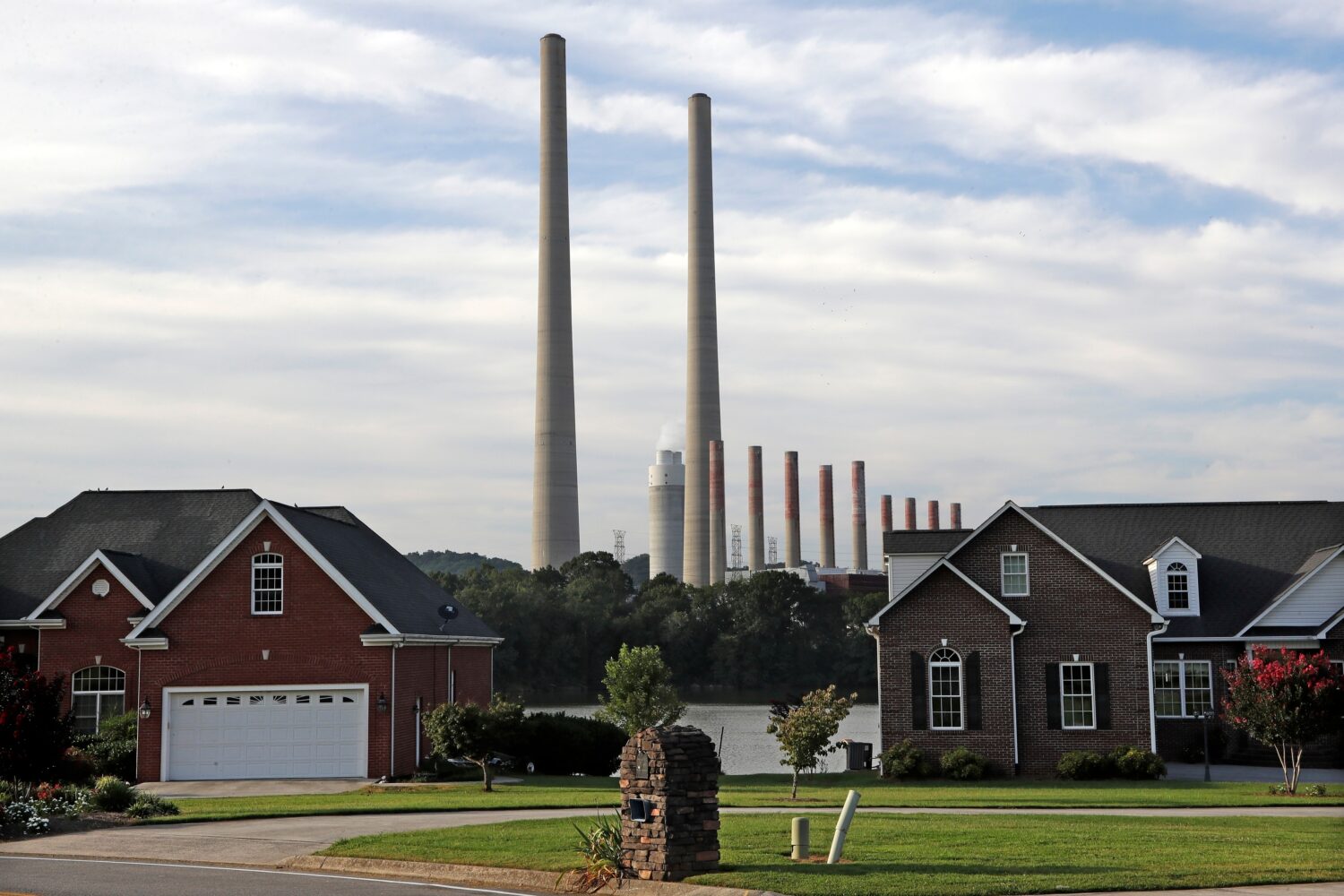 FILE - The Kingston Fossil Plant smokestacks rise above the trees behind homes in Kingston, Tenn, A...