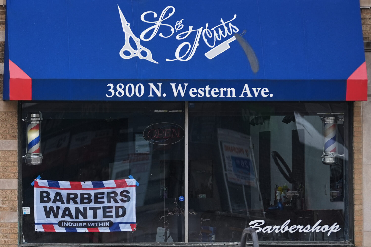 Hiring sign is displayed at a barbershop in Chicago, Thursday, Feb. 5, 2026. (AP Photo/Nam Y. Huh)C...