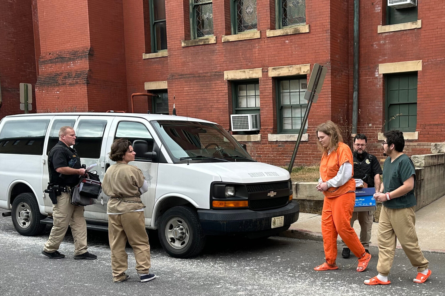 Deputies escort Michelle Zajko, left, Daniel Blank, right, and Jack LaSota, in orange, from the All...