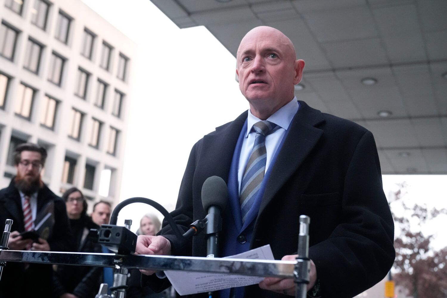 Sen. Mark Kelly, D-Ariz.,speaks to reporters outside of federal court in Washington, Tuesday, Feb. ...