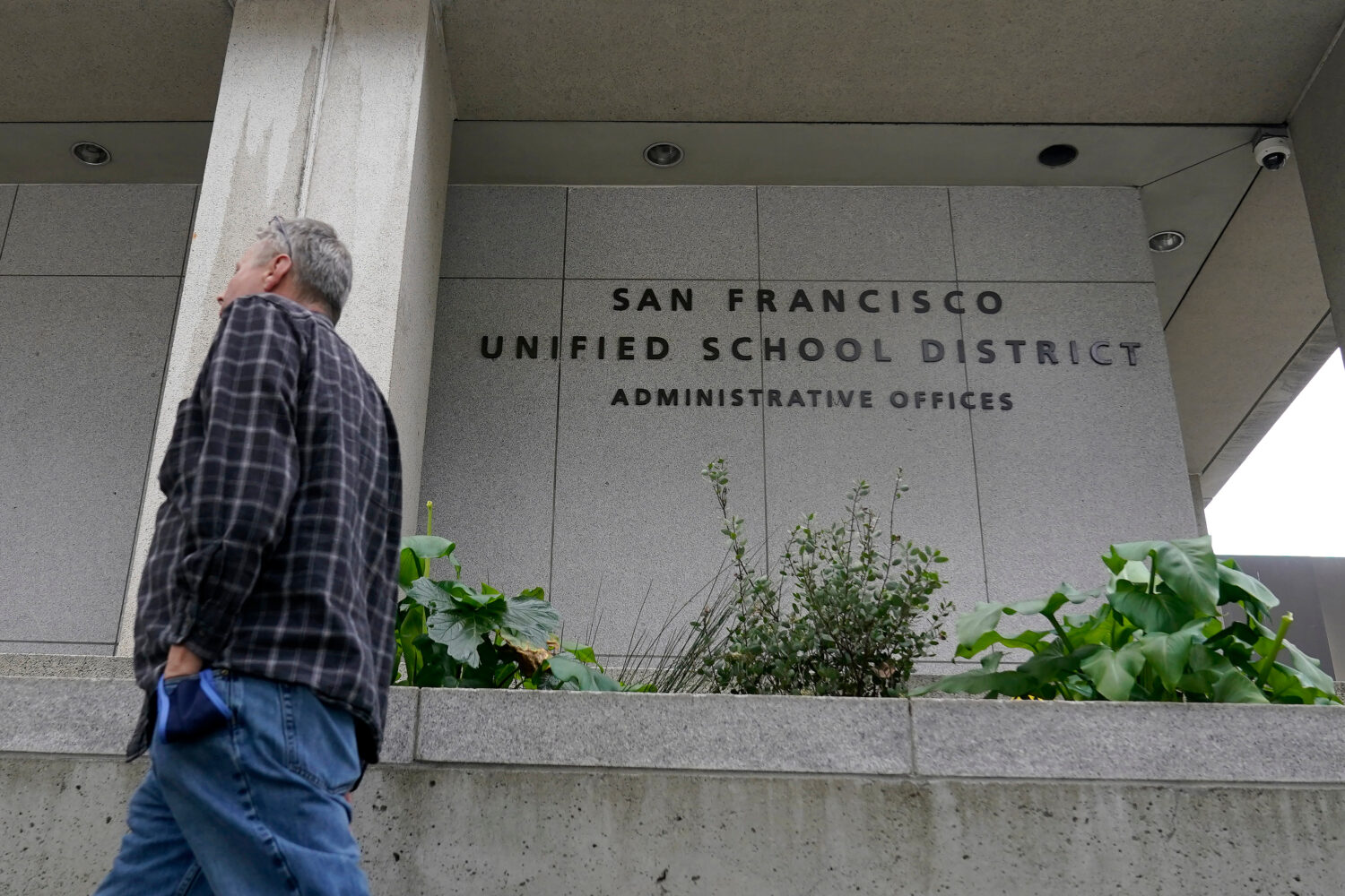 FILE - A pedestrian walks past a San Francisco Unified School District office building in San Franc...