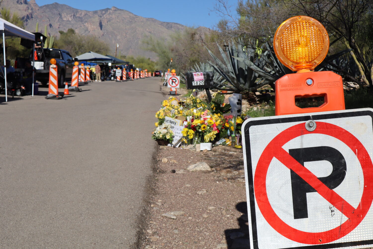 "No parking" signs stand along one side of the road that Nancy Guthrie lives on in Tucson, Ariz., S...