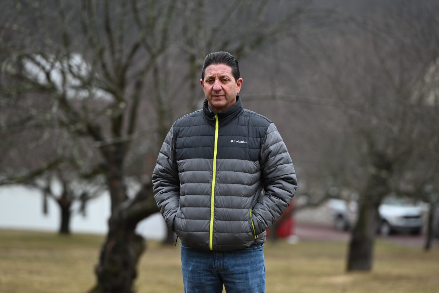 John Zola stands in an apple tree grove on his property on a spot where he says the local electric ...