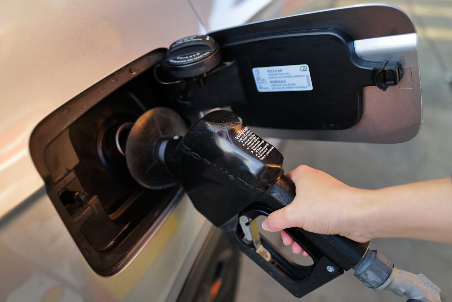 A person fills up her vehicle's gas tank at a gas station in Buffalo Grove, Ill., Thursday, March 1...