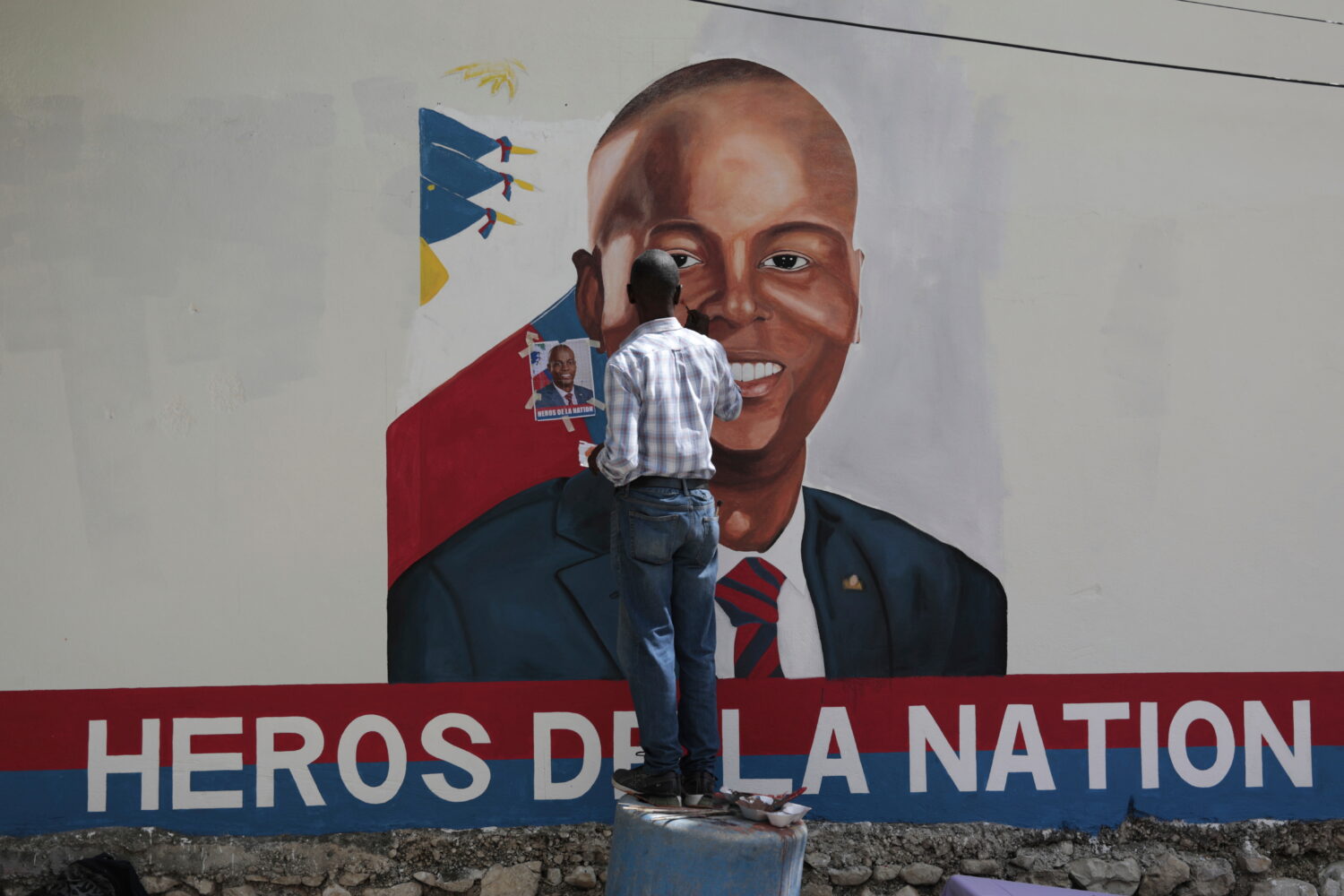 FILE - Artists paint a portrait of slain Haitian President Jovenel Moise near the presidencial resi...