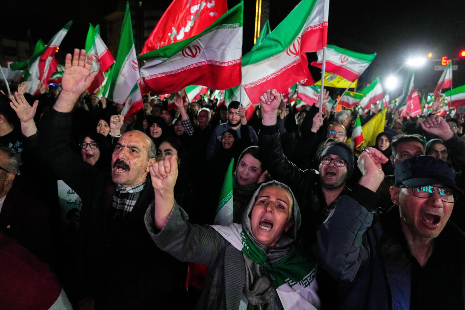 Pro-government supporters chant slogans and wave Iranian flags during a rally, in a square in weste...