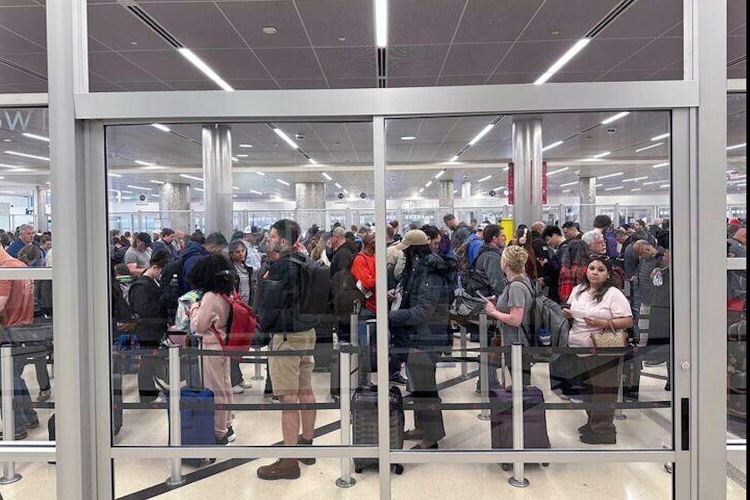 Travelers wait in line at a security checkpoint at Hartsfield-Jackson Atlanta International Airport...