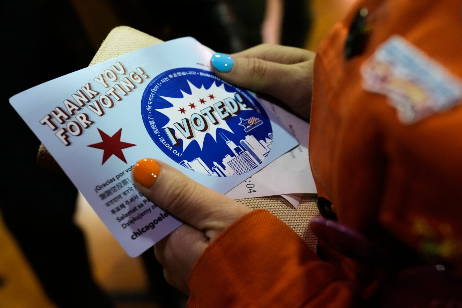 Democratic candidate for Congress, Kat Abughazaleh, holds a "Thank you for voting" sticker after vo...
