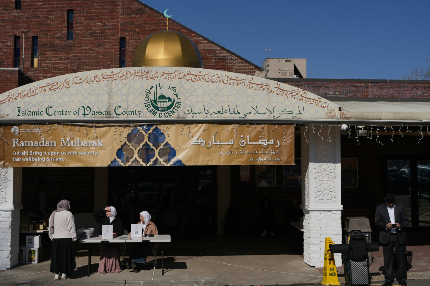 Leen Shella, center, and Haneen Alatiyat, right, prepare to encourage congregants to vote in the Ne...