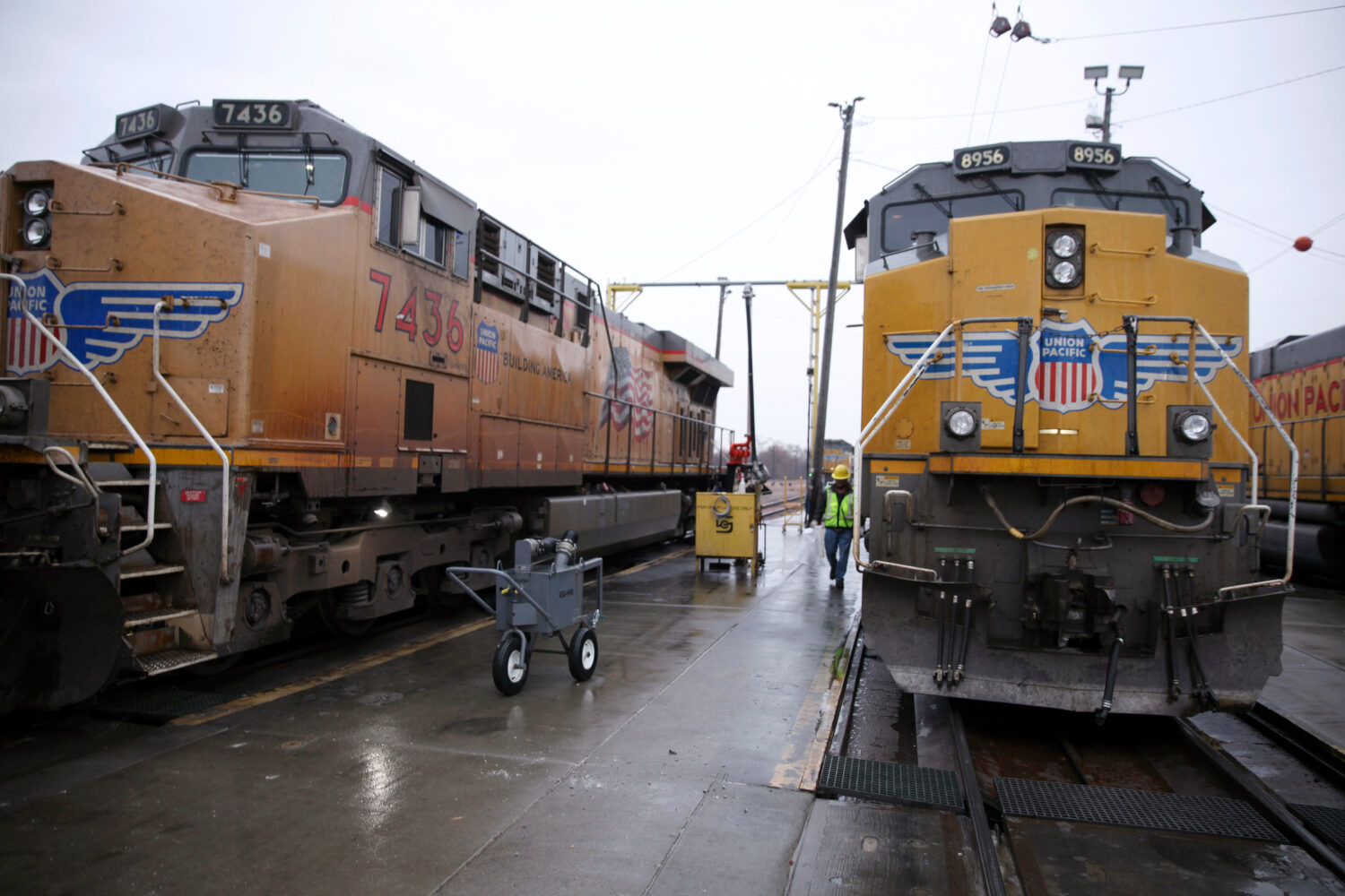 FILE - A Union Pacific worker walks between two locomotives that are being serviced in a railyard i...
