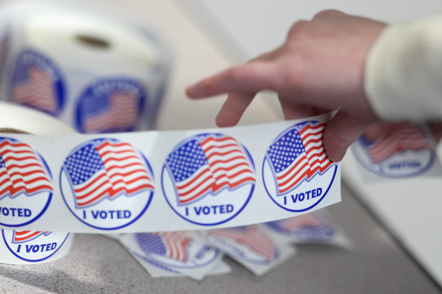 An election worker tears off "I Voted" stickers during the Virginia redistricting referendum at Fai...