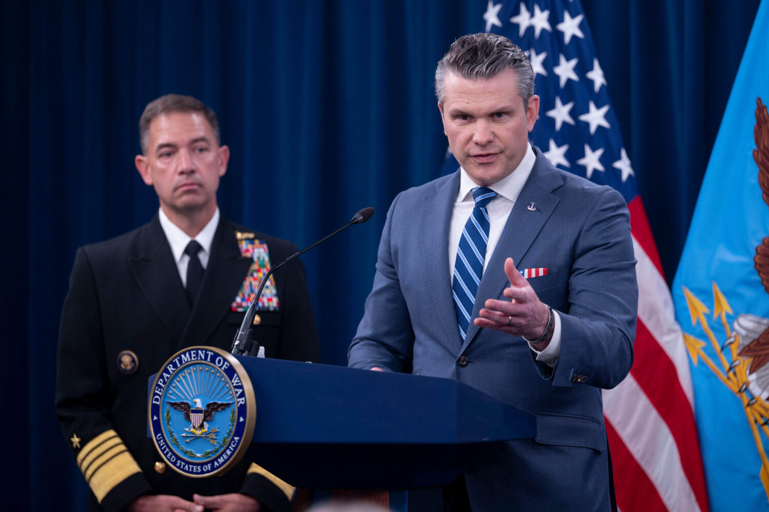 Defense Secretary Pete Hegseth is joined by Adm. Brad Cooper, left, as he speaks to members of the ...