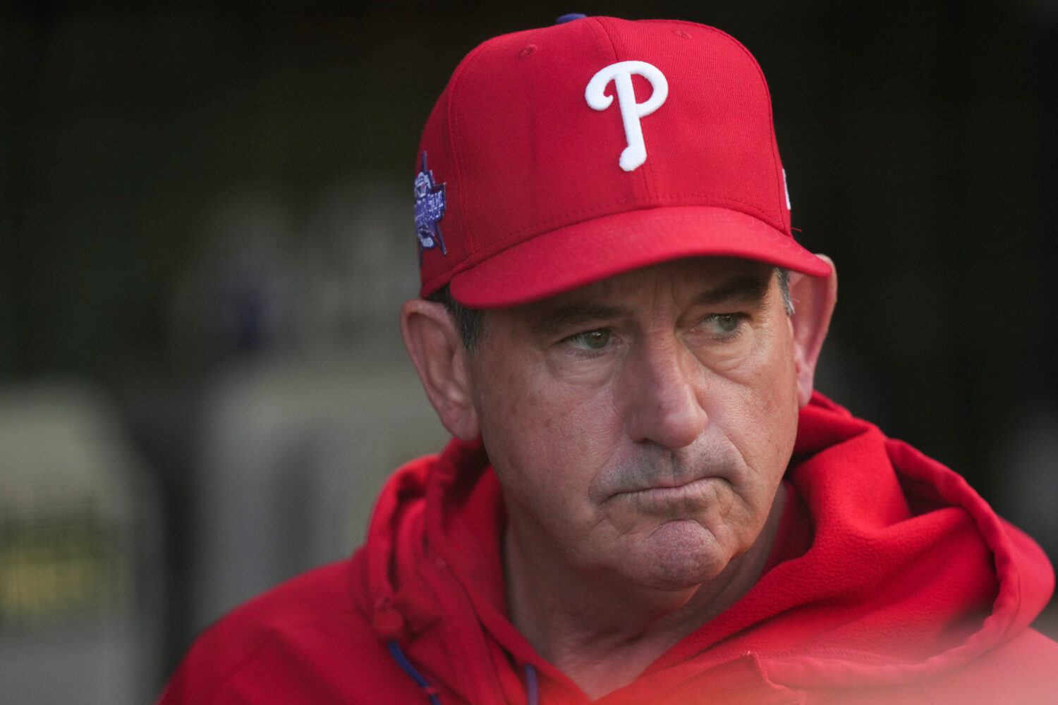 Philadelphia Phillies manager Rob Thomson (49) stands in the dugout before a baseball game against ...