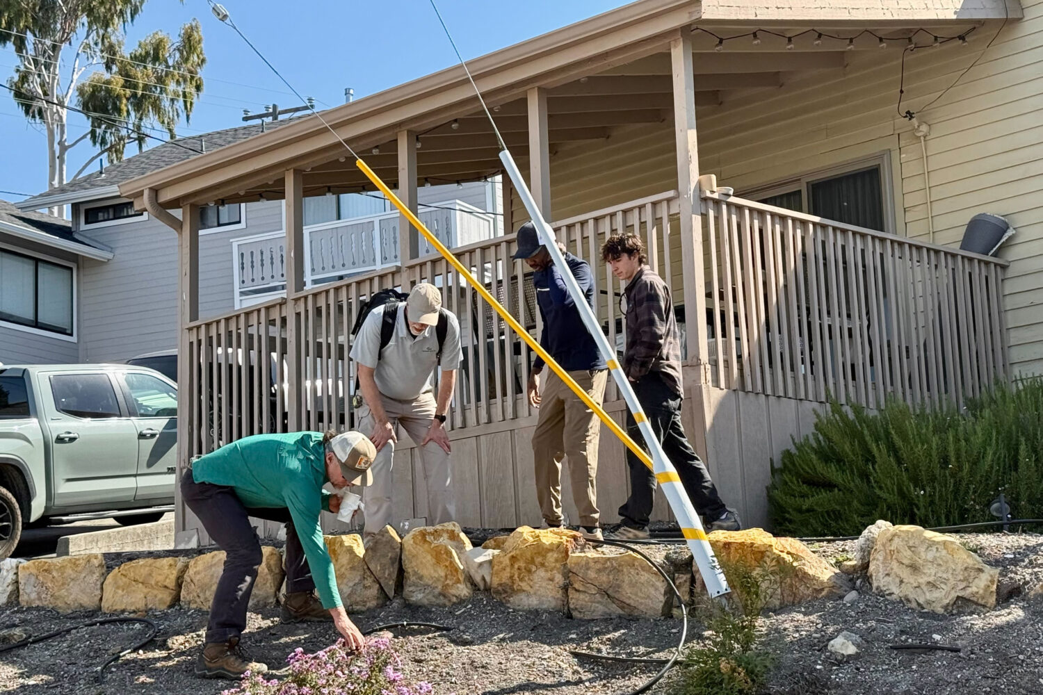 Scientists take samples from the soil Thursday, May 7, 2026, from the neighboring yard of a home in...