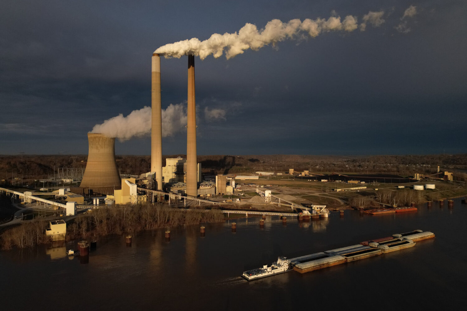 FILE - A barge on the Ohio River moves past the Mountaineer Power Plant, a coal-fired power plant n...