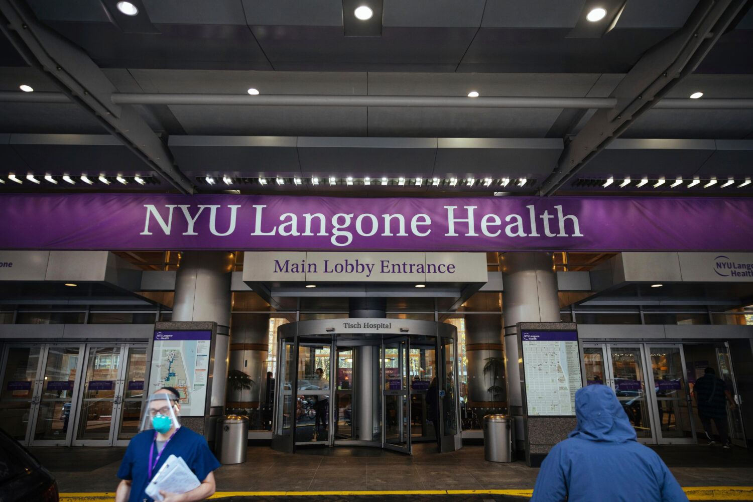 FILE - Health care workers walk in and out of the entrance at NYU-Langone Hospital on Dec. 14, 2020...
