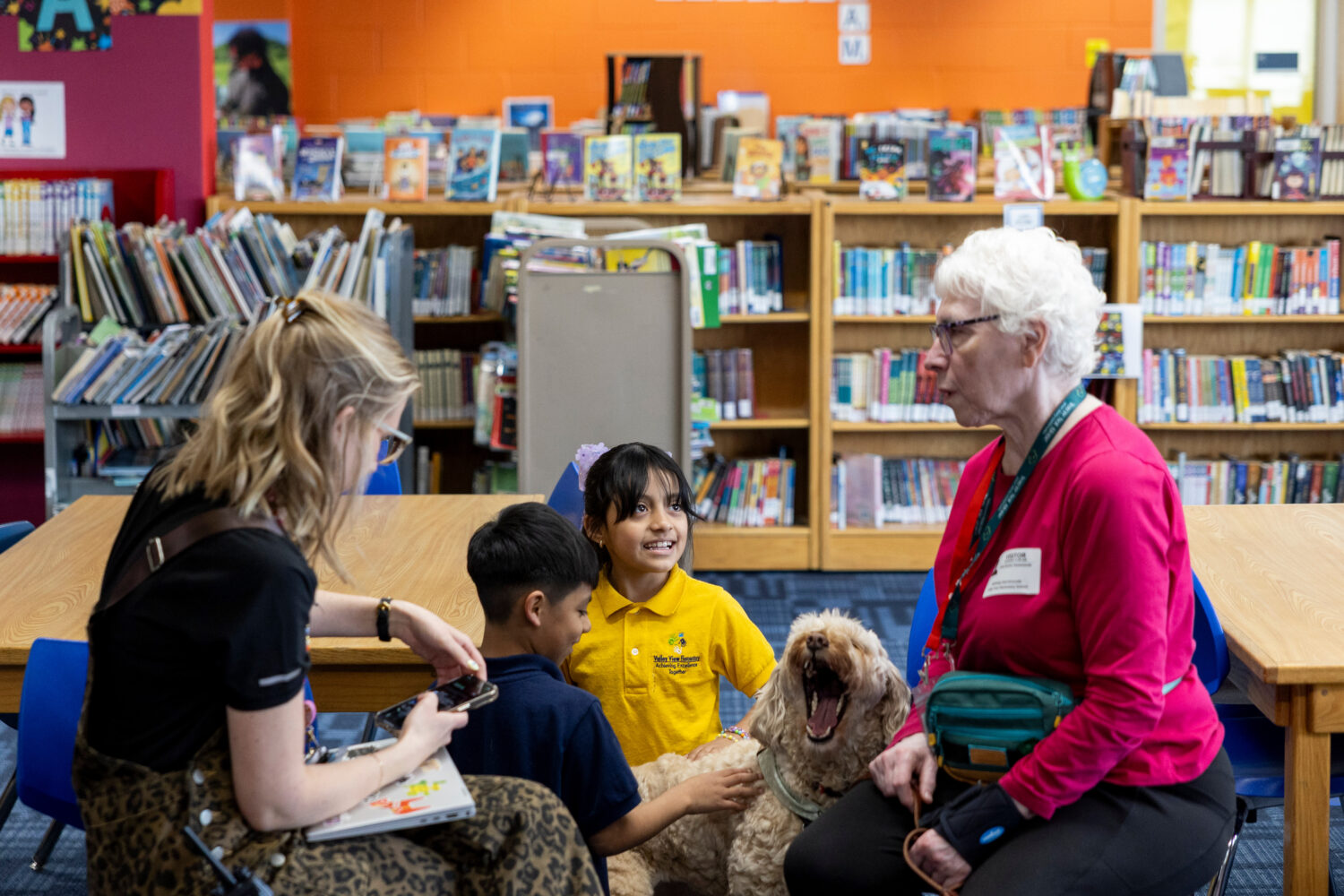 Yesli, center right, pets Sage, a therapy dog, at Valley View Elementary School on April 29, 2026, ...