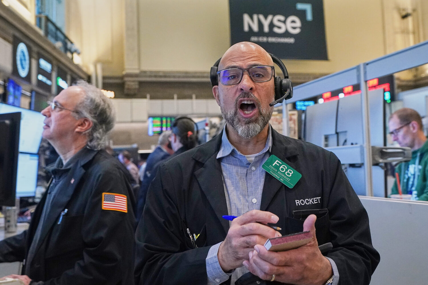 Options trader Steven Rodriguez, center, works on the floor of the New York Stock Exchange, Monday,...