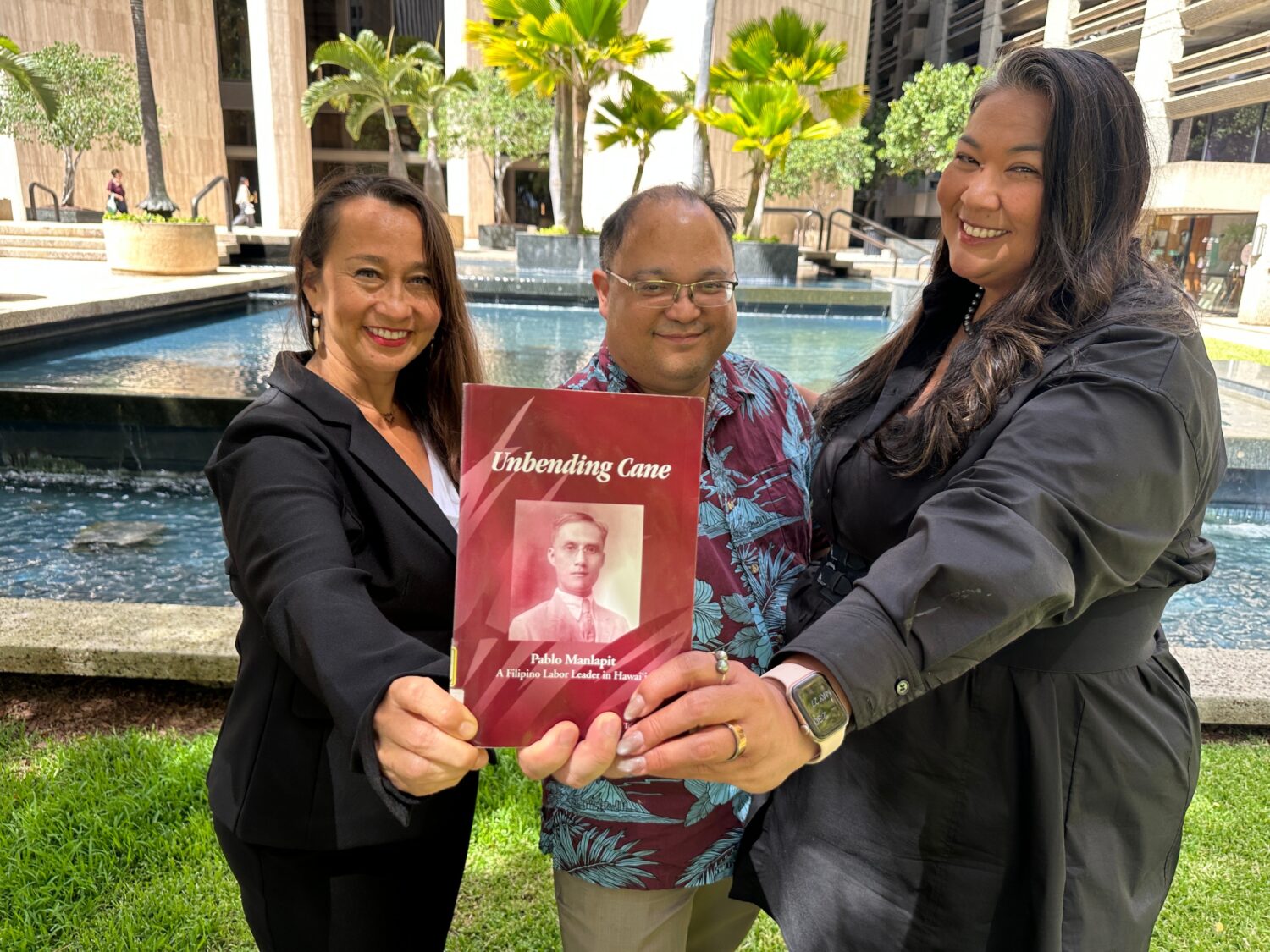 Attorneys Becky Gardner, left, Daniel Padilla, center, and Kainani Collins Alvarez pose with a book...