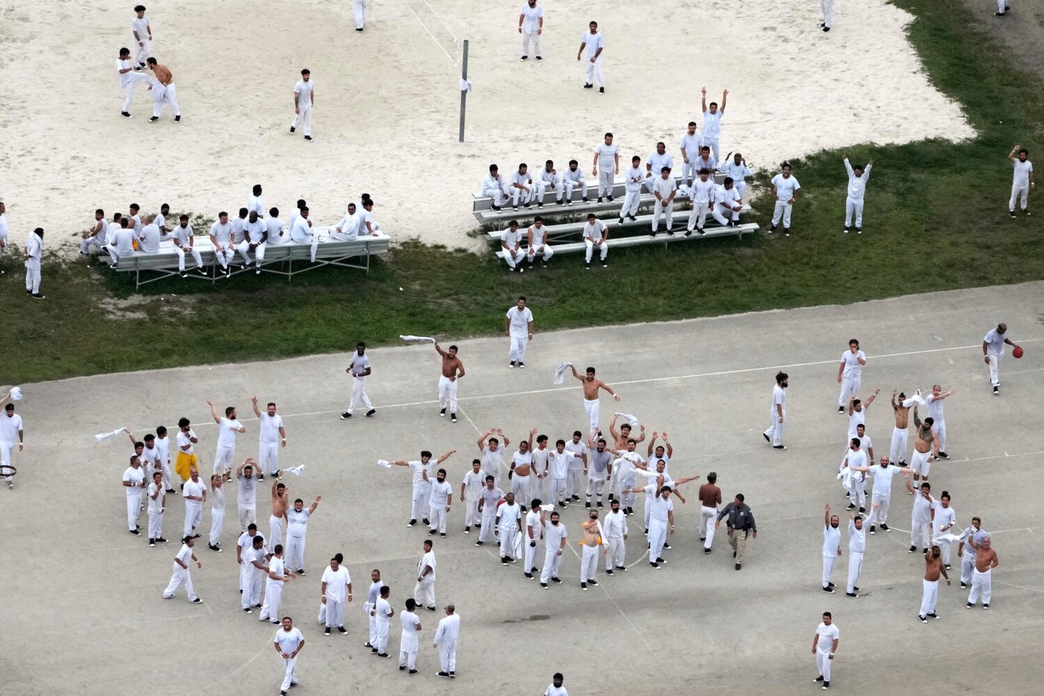 FILE - Detainees wave and spell out a rough SOS to a helicopter flying overhead, at U.S. Immigratio...
