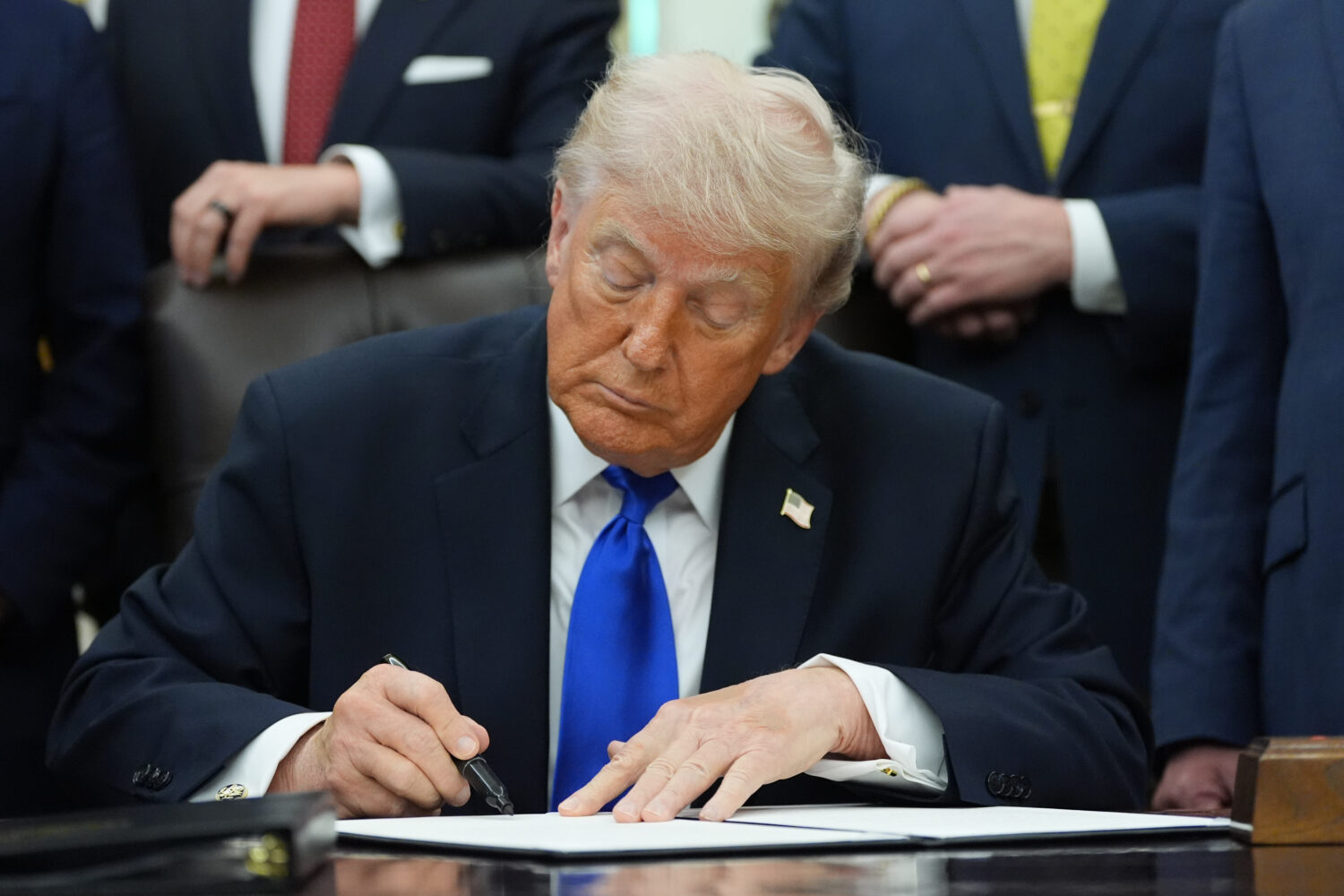 President Donald Trump signs a presidential permit regarding pipeline construction in the Oval Offi...
