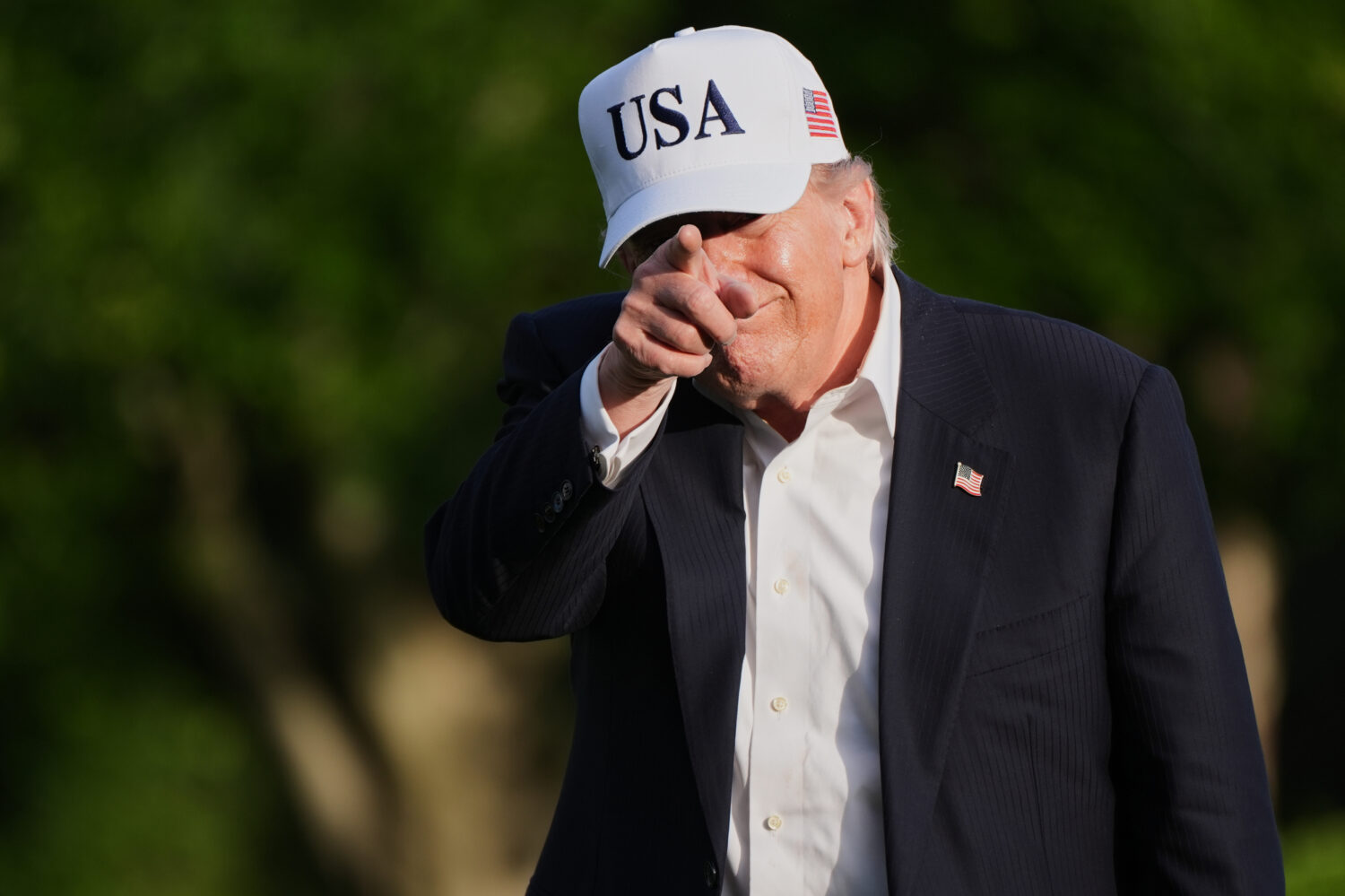 President Donald Trump gestures to reporters as he walks across the South Lawn of the White House, ...