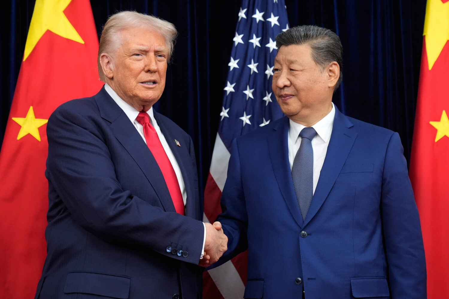 FILE - President Donald Trump, left, and Chinese President Xi Jinping shake hands before their meet...