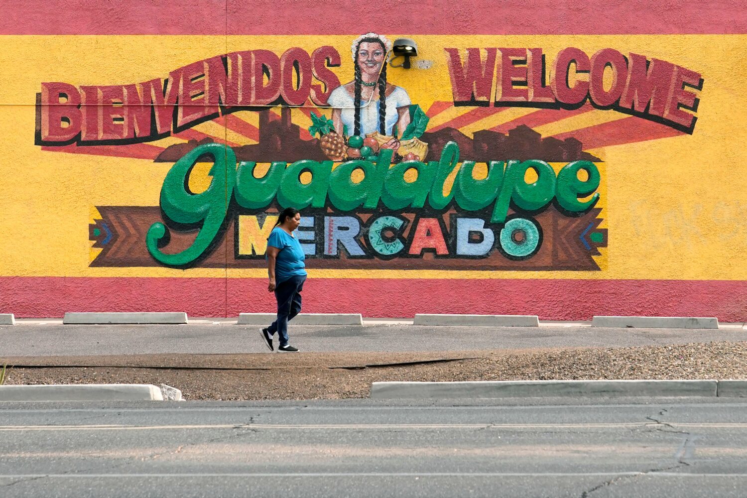 A person walks past a mural promoting Guadalupe, Ariz., May 19, 2026. (AP Photo/Ross D. Franklin)Cr...