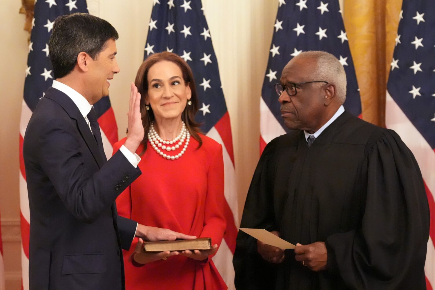 Justice Clarence Thomas, right, administers the oath during the swearing in of Kevin Warsh as Chair...