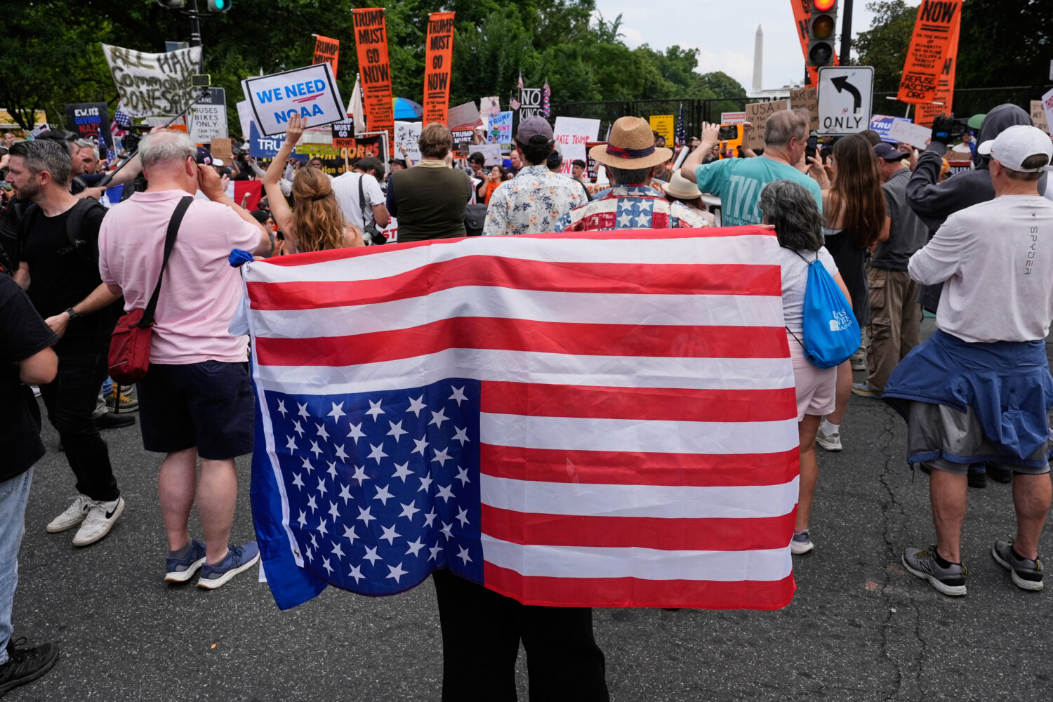 FILE - A demonstrator carries an American flag upside-down near the White House during a protest ta...