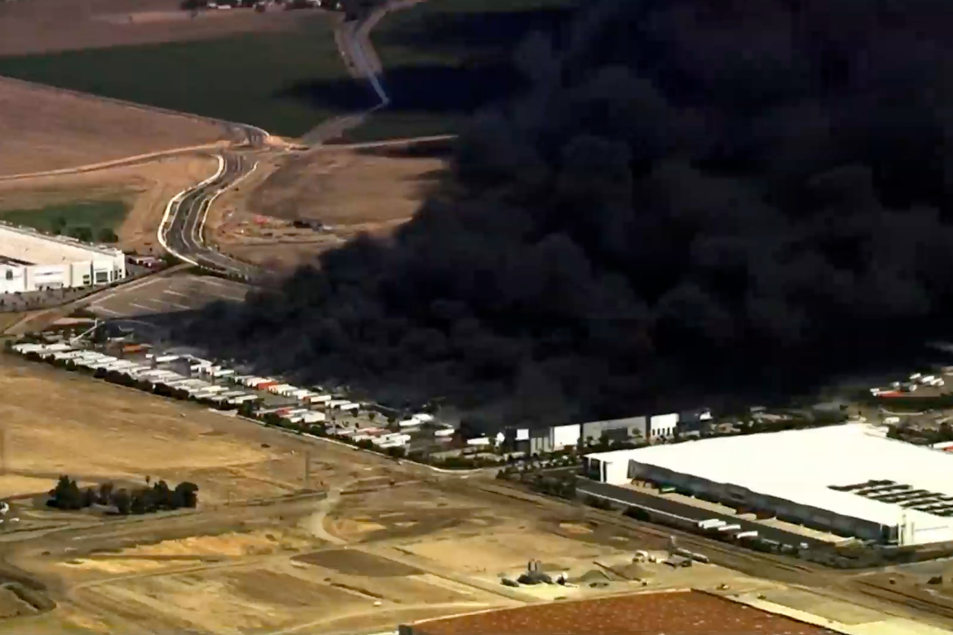 This image from aerial video shows black smoke pouring into the sky from a fire at a medical equipm...