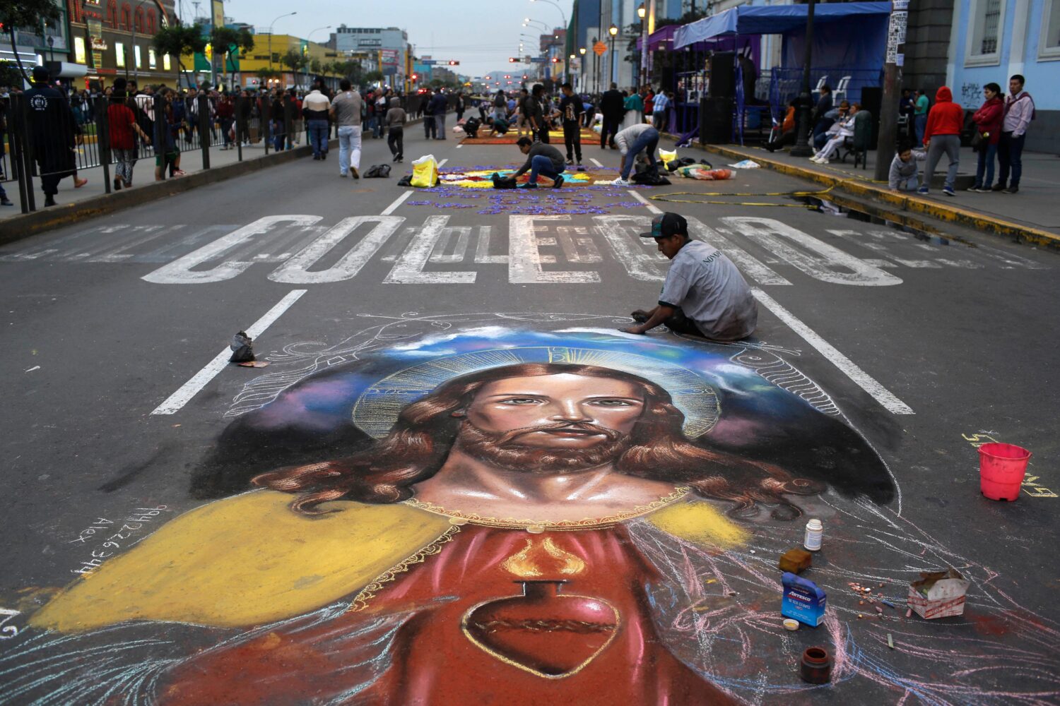 FILE - A man works on a chalk drawing depicting the Sacred Heart of Jesus, Oct. 28, 2017, in Lima, ...