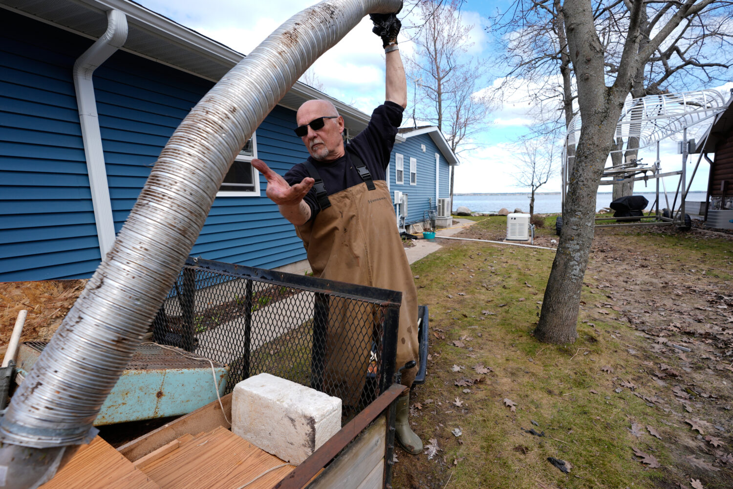 Tom Peterman cleans up outside his home from recent floods at Black Lake on Wednesday, April 29, 20...