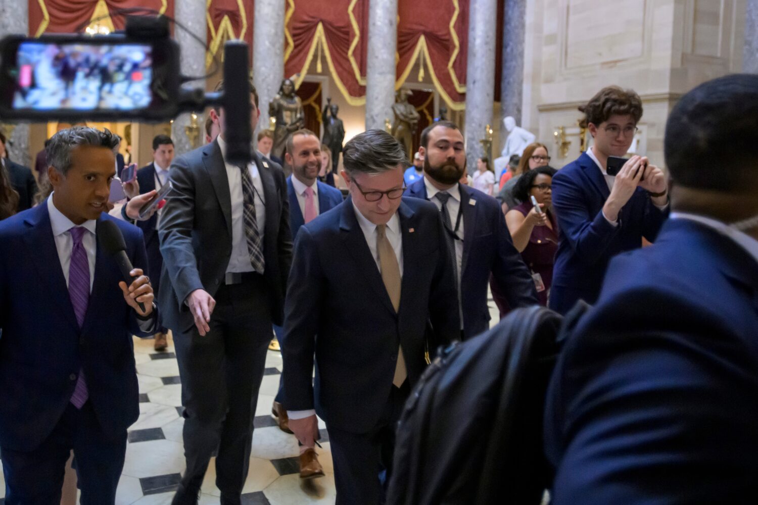 Speaker of the House Mike Johnson, R-La., talks with reporters as he walks to his office following ...