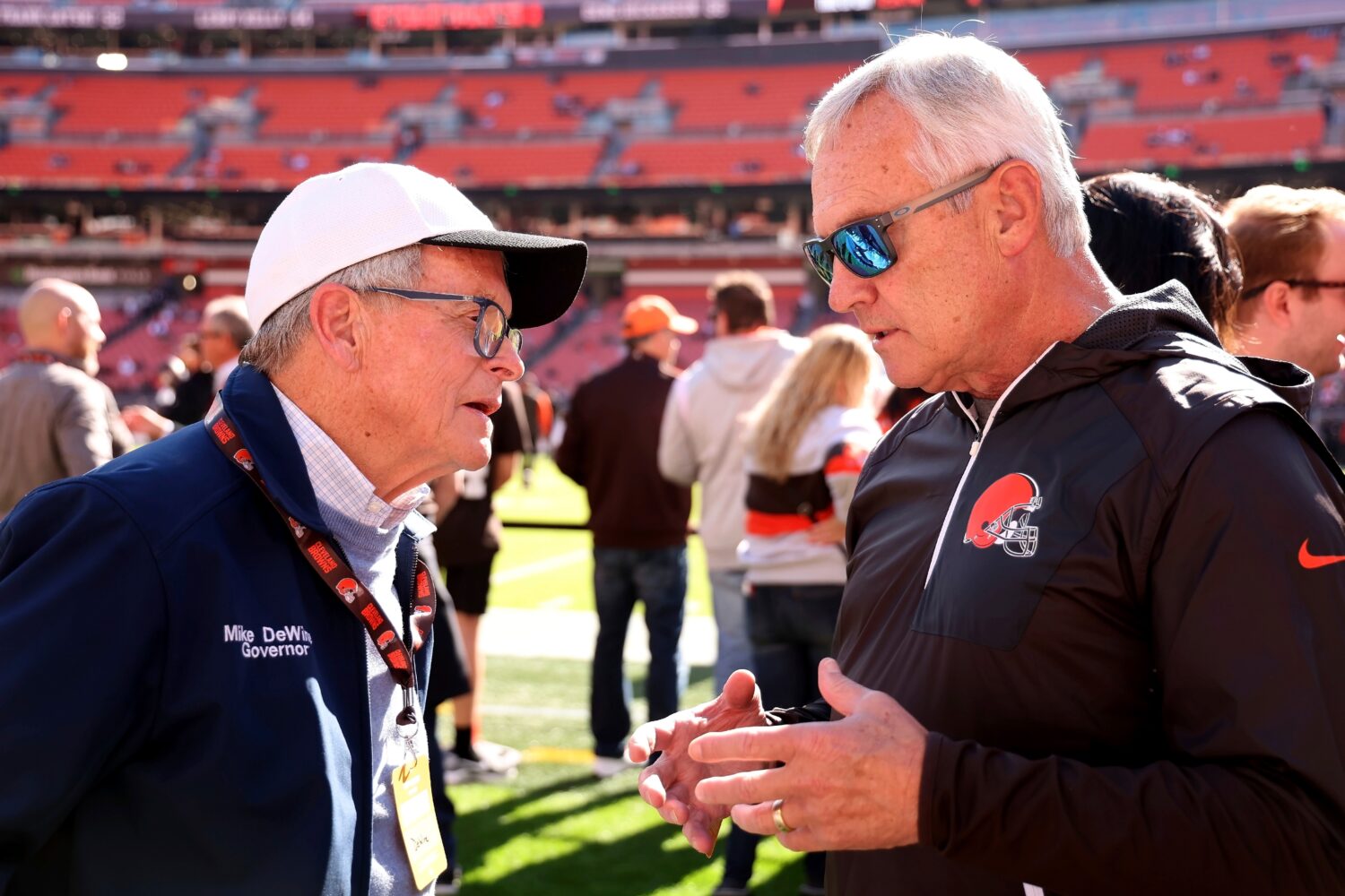 FILE - Ohio Gov. Mike DeWine talks with former Ohio State coach Jim Tressel while standing on the s...