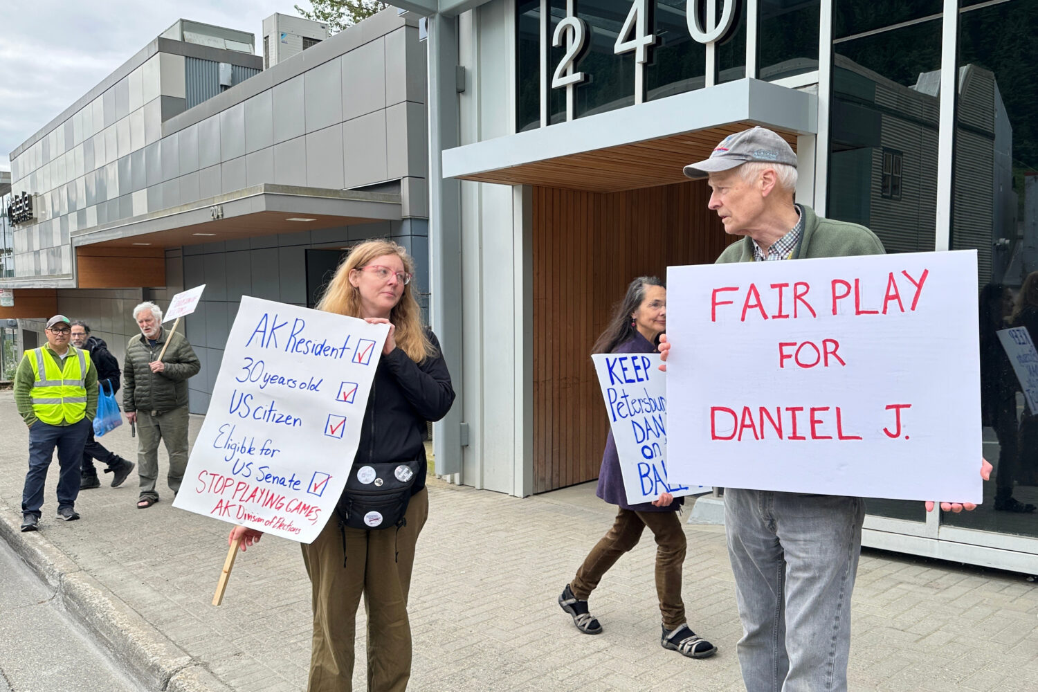 Anjuli Grantham, left, and Ben Muse protest with others outside the Alaska Division of Elections of...