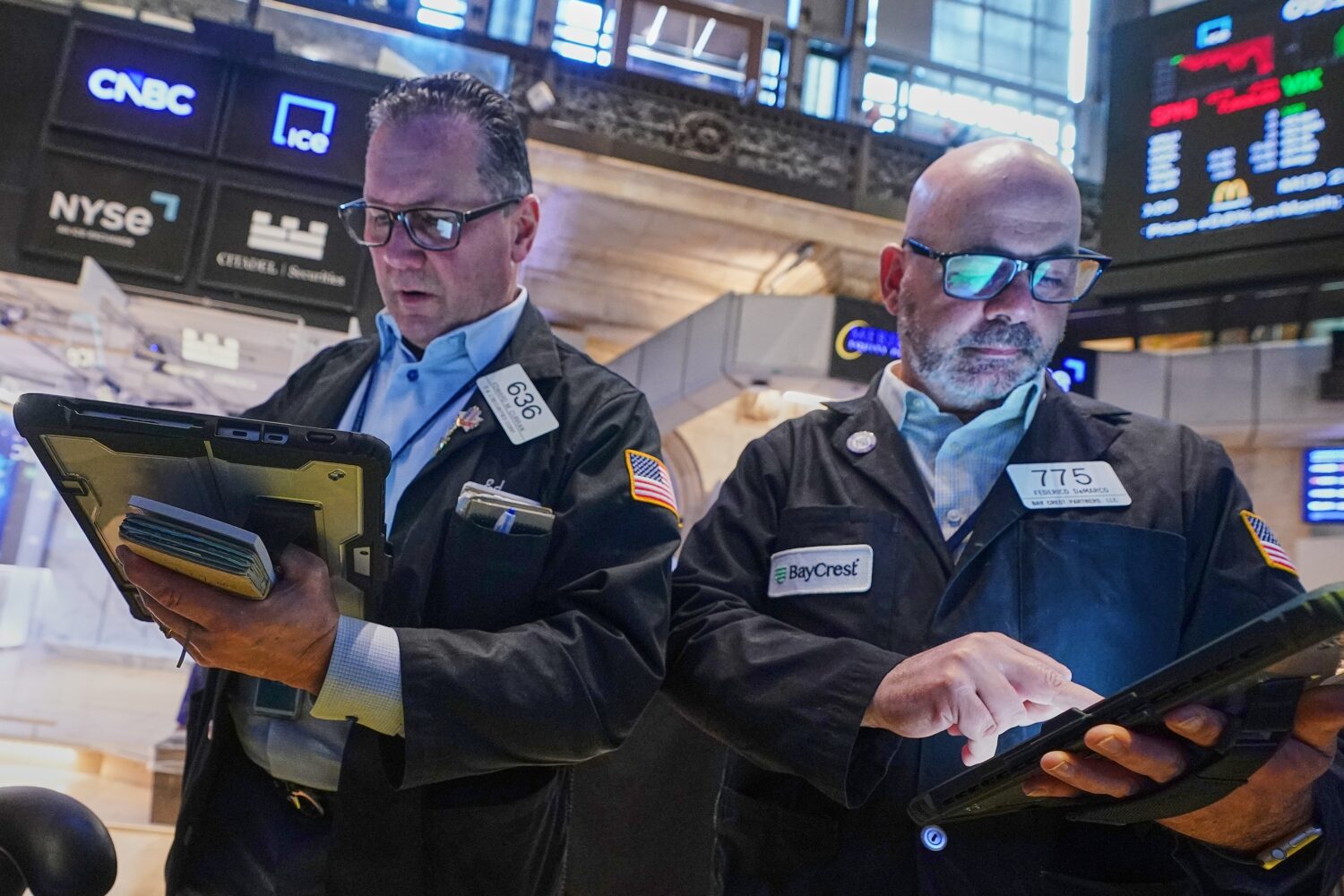 Traders Edward Curran, left, and Fred Demarco work on the floor of the New York Stock Exchange, Wed...