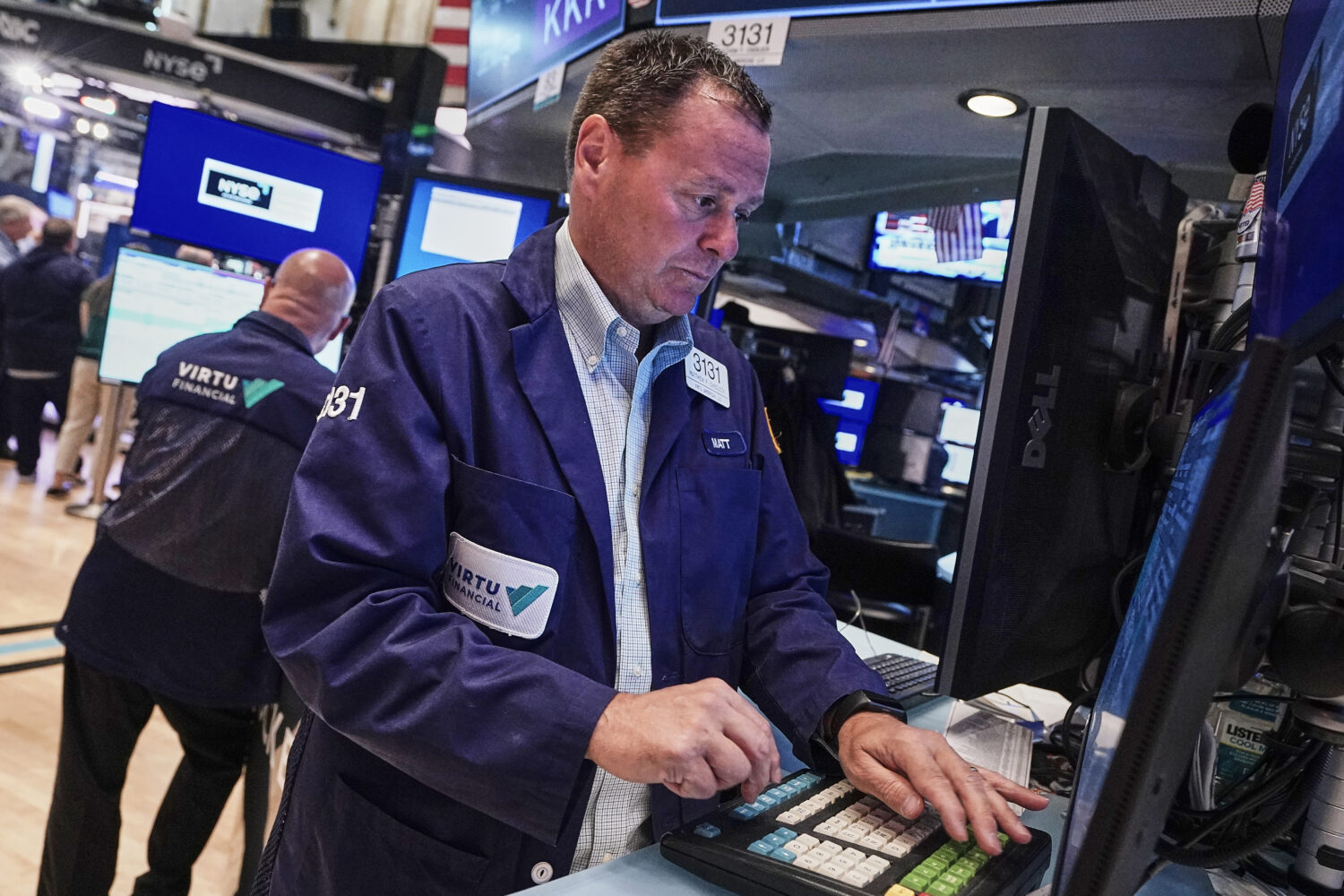 Trader Matthew Cheslock, right, works on the floor of the New York Stock Exchange, Tuesday, June 16...